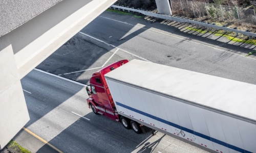 Bird's eye view of a red truck moving down a highway