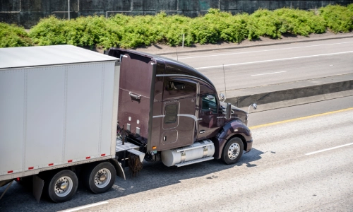 A truck driving in the left lane of a highway