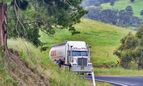 A freight truck with grassy hills in the background