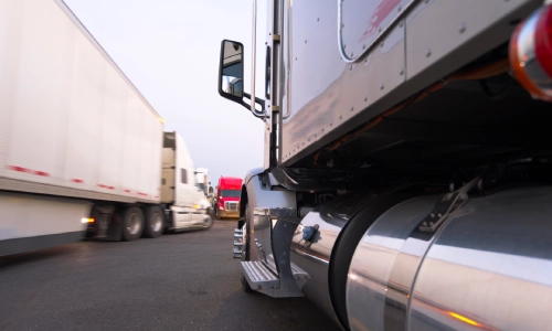 A view between two freight trucks on the highway