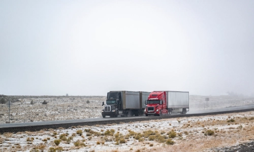 A freight truck passing a slower freight truck