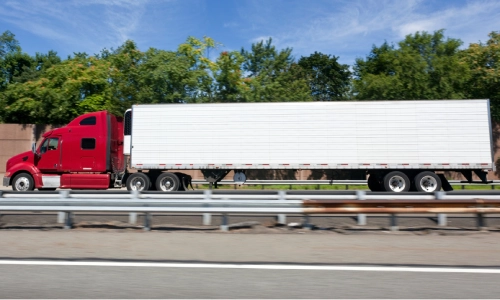 A red freight truck moving fast